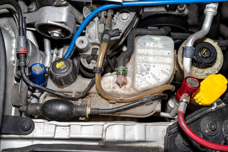 On the valve from the air conditioning system in the car, there is a blue and red quick coupler for...