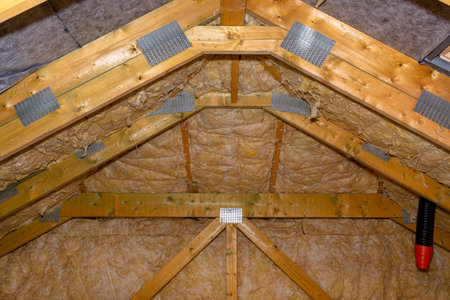 Insulation of walls and ceiling in the attic made of mineral wool between trusses, tied with...