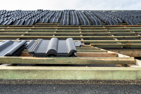 Roof ceramic tile arranged in packets on the roof on roof battens. Preparation for laying tiles on a boarded roof.の写真素材