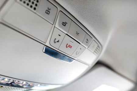 Top control panel buttons in a luxury car, SOS button visible.の写真素材