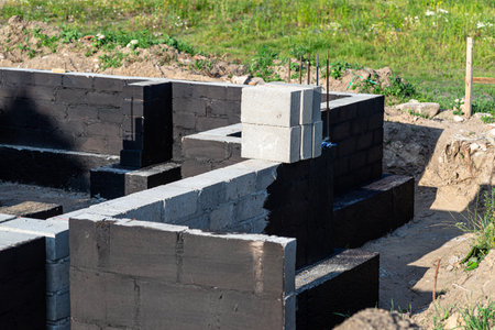 Footings made of concrete blocks painted with black dispersion asphalt-rubber mass, reinforced concrete pillars visible.の写真素材