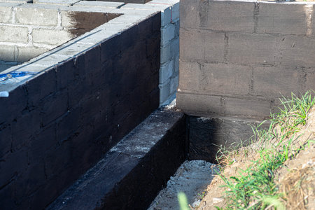 Footings made of concrete blocks painted with black dispersion asphalt-rubber mass, reinforced concrete pillars visible.の写真素材
