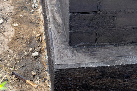 Footings made of concrete blocks painted with black dispersion asphalt-rubber mass, reinforced concrete pillars visible.の写真素材