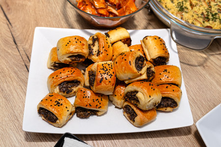 Baked patties in dough lying on a plate on a Christmas table in Poland.