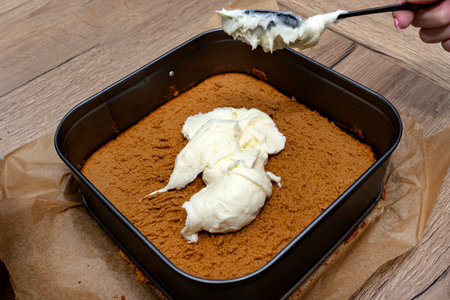 Preparation of Polish cake, fudge with custard cream, the woman applies the pudding mass.の写真素材