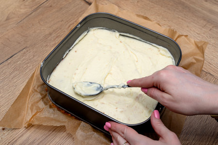 Preparation of Polish cake, fudge with custard cream, the woman applies the pudding mass.の写真素材