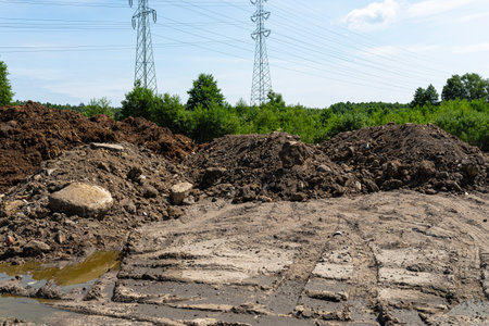Digging out peat from marshy swamps, visible rubble and stones piled next to the peat.の写真素材