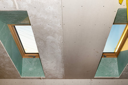 Roof window covered with blue plaster, visible vapor-permeable foil.