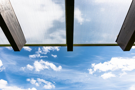 The terrace behind the house has visible beam connections, the roof is covered with polycarbonate.
