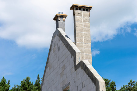 The gable walls are poured with concrete, with visible system chimneys.の写真素材