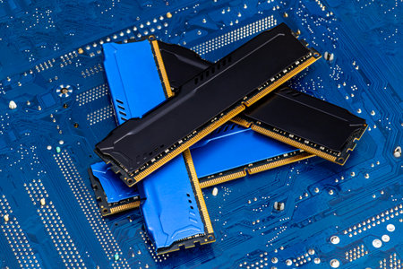 Four DDR memory chips in different colors lying on a blue printed circuit board.の写真素材