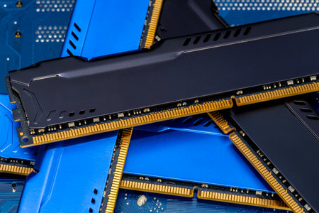Four DDR memory chips in different colors lying on a blue printed circuit board.