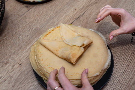 Woman hands are preparing handmade crepes