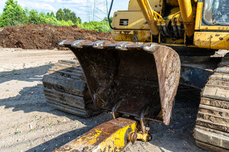 Heavy duty excavator bucket digging earth and preparing ground for development