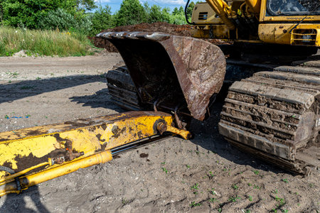 Long reach excavator bucket and arm resting on dirt at a construction site