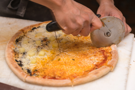 chef cutting pizzaの写真素材