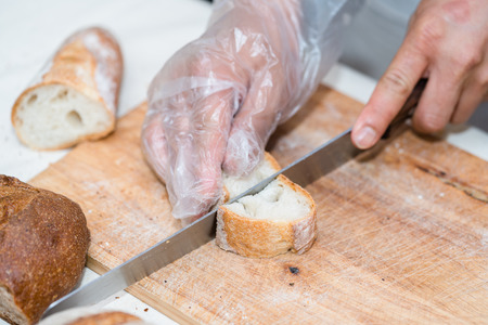 chef slicing bread in th kitchenの写真素材