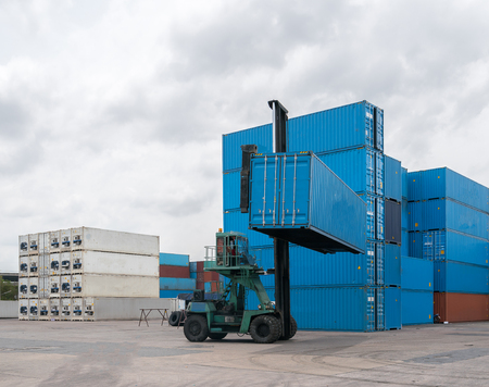 Crane lifting up container in yardの写真素材
