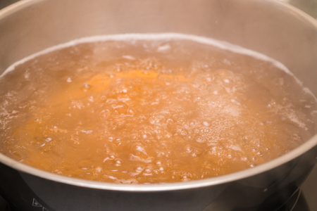 Boiling soup in a kitchen pot as a symbol of cooking or food preparationの写真素材