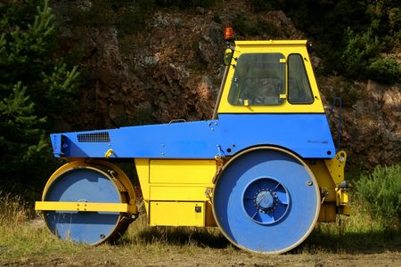 Blue and yellow road roller out of workの写真素材