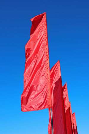 Red festive flags during a holiday against the blue sky