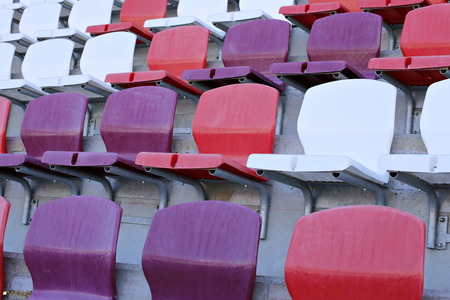 Multicolored plastic chairs on the stadium