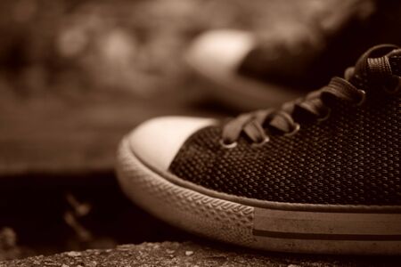 Gray shoes and shoelaces up close in vintage model. An elegant lifestyle sneaker on a rustic wooden surface. Details of classic sport footwear.の写真素材