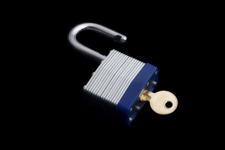 open metal lock with key isolated on black backgroundの写真素材