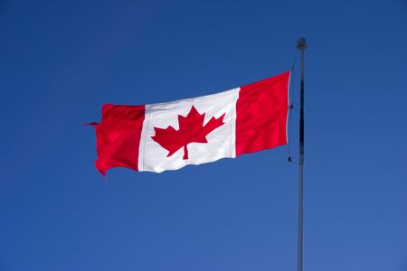 Backlit Canadian flag waving in the wind