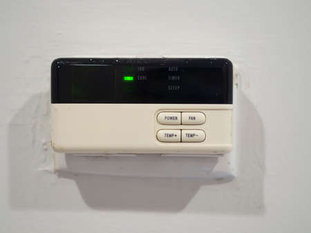 Wall mounted air conditioner remote control On a white cement wall