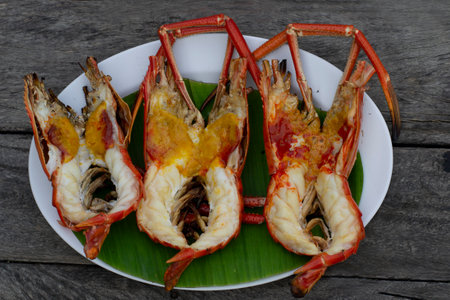 Grilled river prawns in a white plate on a grayish brown wood backgroundの写真素材