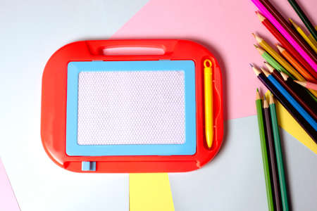 white magnetic board on a bright colored paper background ready to go to school