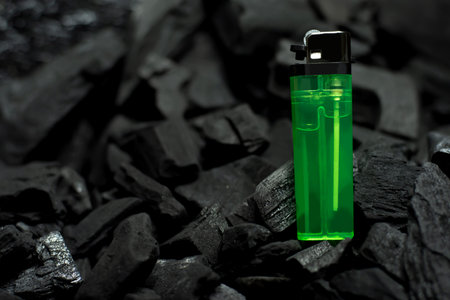 green lighter On a black background with charcoaの写真素材