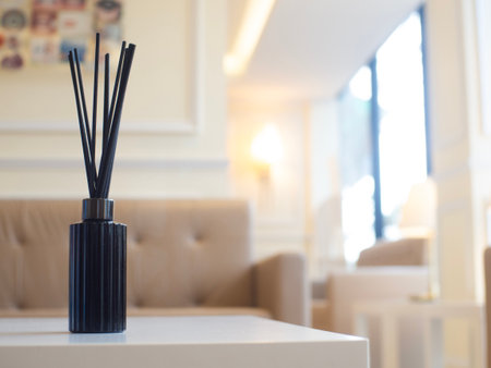 Scented reed diffuser in a black bottle placed on the center of the guest room. There is a sofa in the back. ready to welcome guestsの写真素材