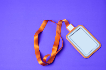 Empty orange employee card With strap placed on a purple background make it look clear For inserting...
