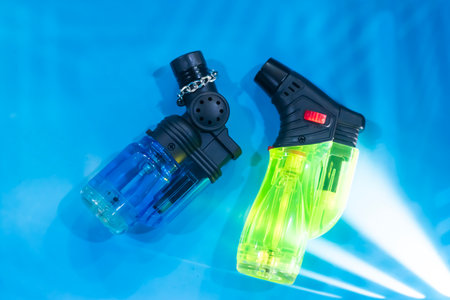 two powerful lighters, blue and green, placed on a blue background, light color