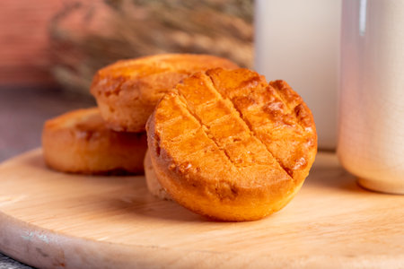Close up of fresh baked buns with milk on wooden table.の写真素材