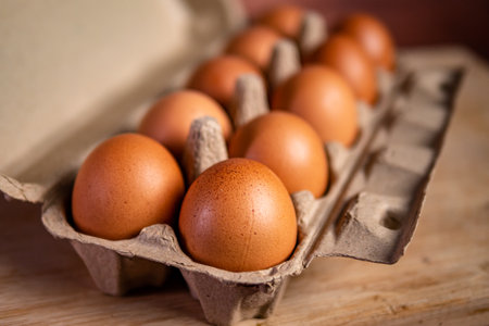 Eggs in carton box on wooden background. Close upの写真素材