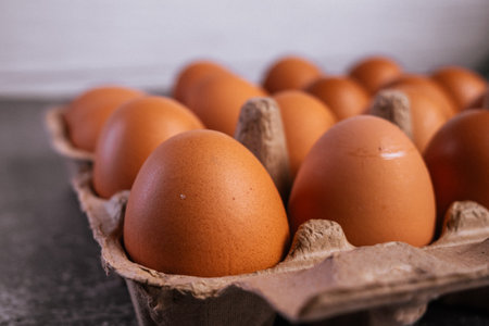 Eggs in a cardboard box on a wooden background. Selective focus.の写真素材