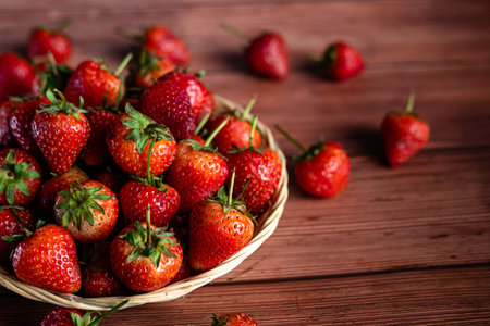 Strawberries in a basket on a wooden background. Selective focus.の写真素材