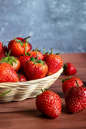 Strawberries in a basket on a wooden background. Selective focus.の写真素材