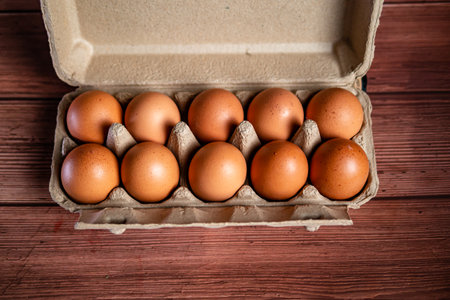 Eggs in a cardboard box on a rustic wooden backgroundの写真素材