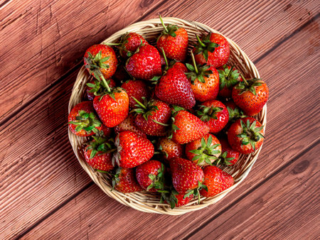 Fresh strawberries in a basket on a wooden background. Top view.の写真素材
