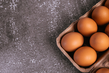 Box with fresh eggs on grey background, top view. Space for textの写真素材