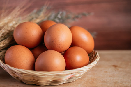 Eggs in a basket on wooden background. Selective focus.の写真素材