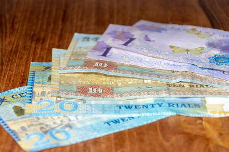 The Riyal Currency of the Oman notes spread out on the table. Money exchange.