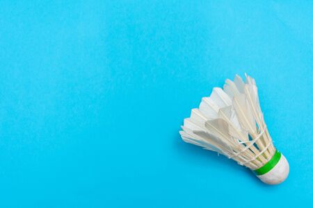 Badminton shuttlecock or birdie on a solid bright blue flat lay background symbolizing sports and activity with copy space.の写真素材