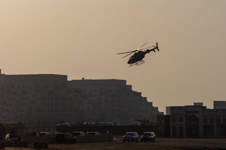 Military combat and war with helicopter flying into the chaos and destruction. Military concept of...