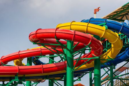 Colorful water Park twisted water slide amusement resort for luxury children and family vacations on a warm sunny tropical day.の写真素材