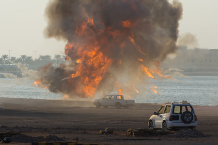 Military strike or bomb in war causes fire ball and explosion amid  cars and town in chaos. Military war concept. Strength, power, force, fire, explosion.のeditorial素材